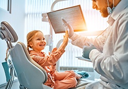 A girl high fiving her dentist.