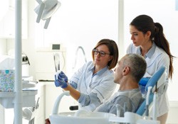 a dentist showing a patient his dental X-rays