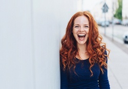 person standing against a wall and smiling