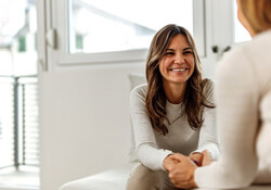 a woman smiling while talkign to someone