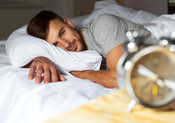 a man smiling after waking up in bed