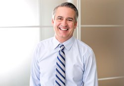 man in light blue dress shirt and tie smiling with dental bridge in Green Hills 