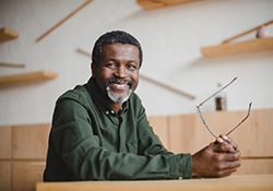 older man smiling while sitting on table 