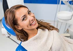 Woman smiling while visiting her emergency dentist in Green Hills