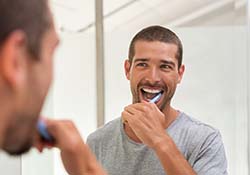 Man brushing teeth to prevent dental emergencies in Green Hills