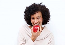 woman biting into a red apple 