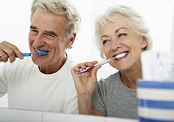 elderly couple brushing their teeth together 