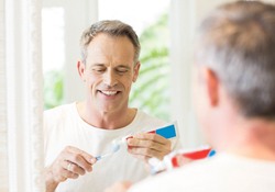 A man brushing his teeth to keep his dental implants in Green Hills clean