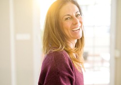 A middle-aged woman showing off her healthy smile in Green Hills