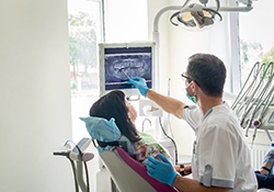 a dentist showing a patient their X-ray