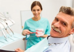 a patient smiling after receiving dentures