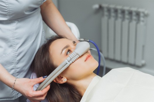 Hands placing nitrous oxide mask over patient’s nose