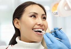 Woman smiling at her Nashville emergency dentist during checkup