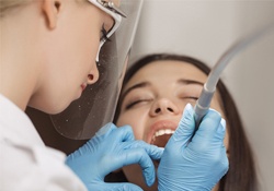 A dentist performing dental work on a female patient
