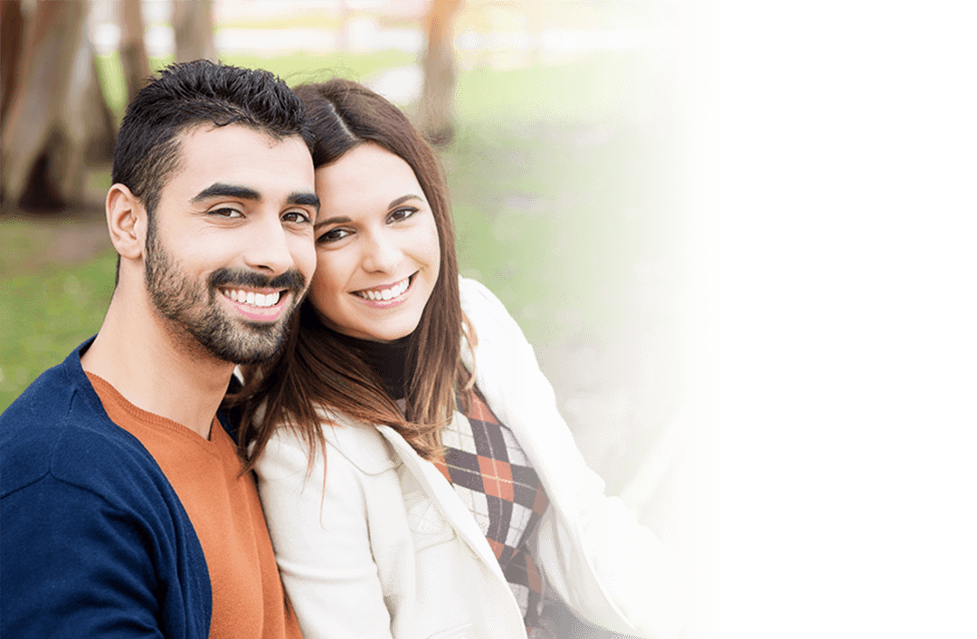 Smiling man and woman sitting outdoors