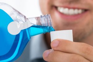 A man pouring mouthwash.