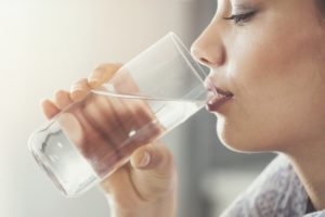 person drinking a glass of water