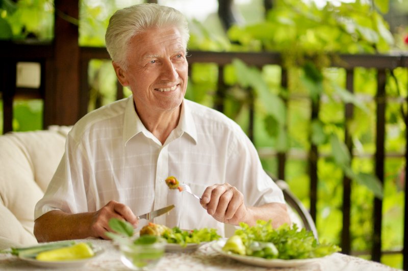 man enjoying a meal with dentures in Green Hills