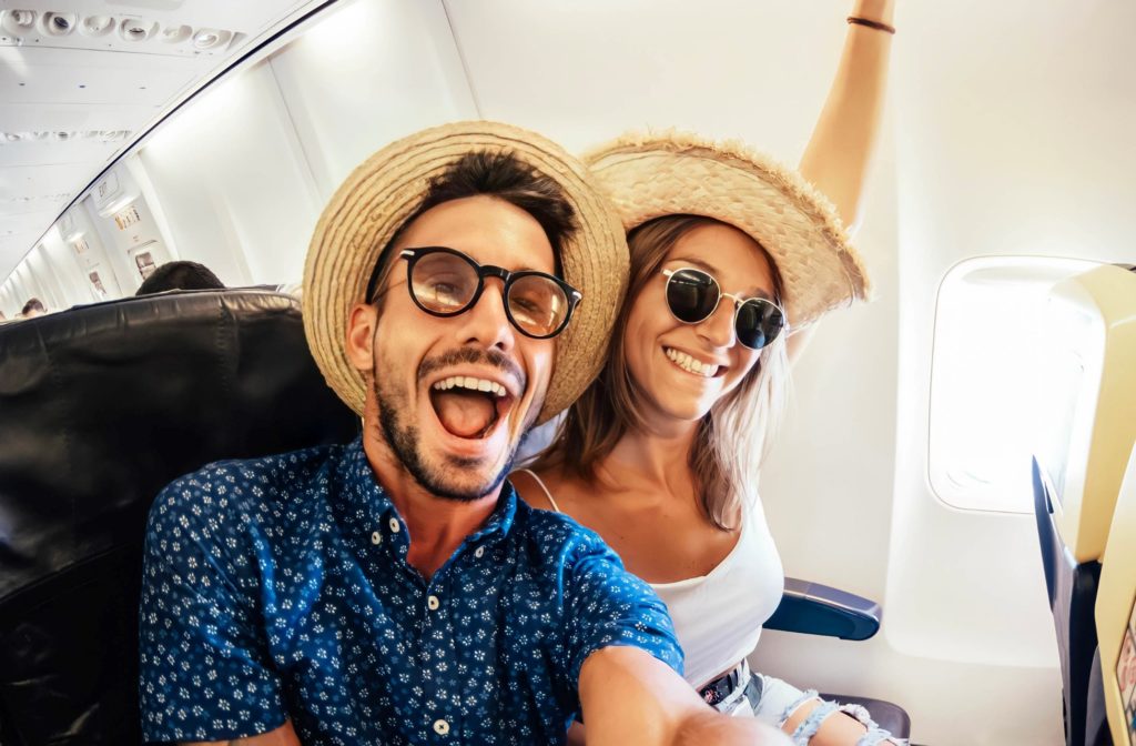 Couple smiling while taking selfie in airplane
