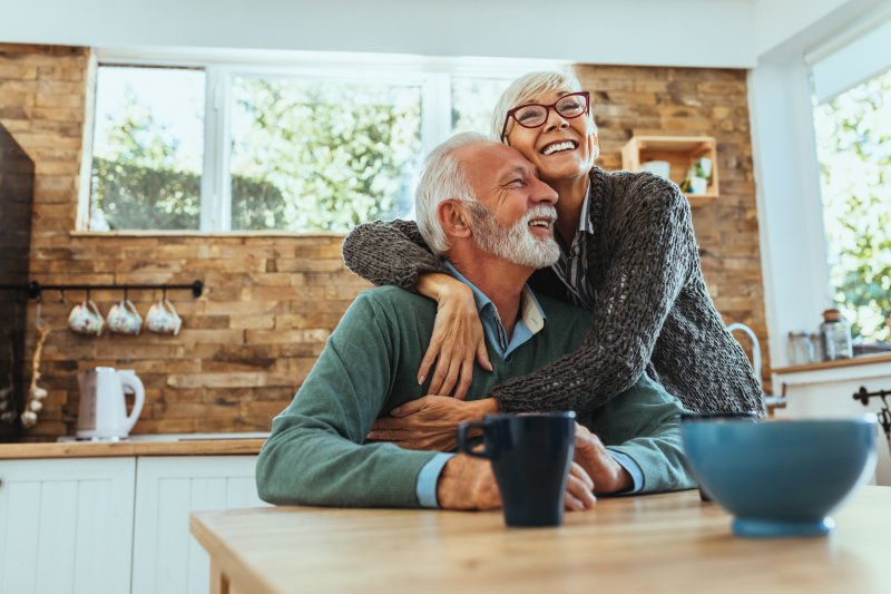 Older couple embracing while wearing dentures