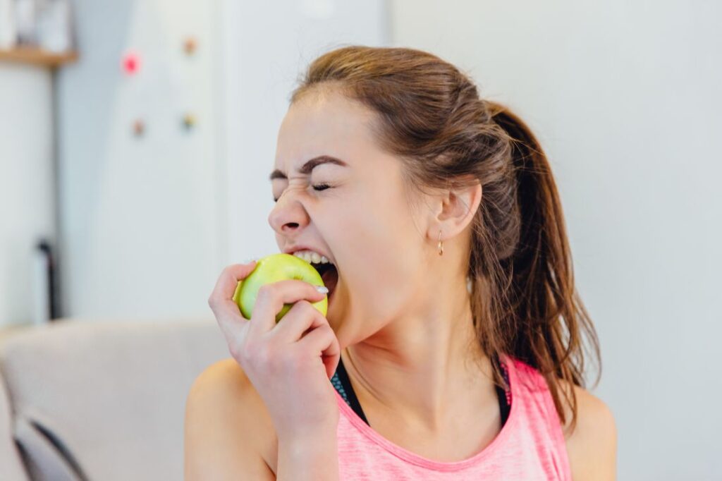 A woman biting an apple