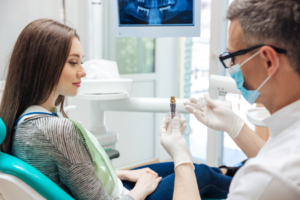 a patient examining a dental implant model